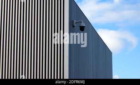A security camera on the the side of Bexhill Museum with a wall with strong Vertical lines. Stock Photo