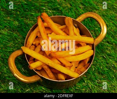 french fries in a metal bowl with grean background Stock Photo