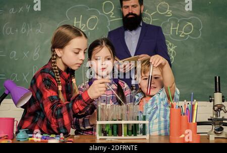 children making science experiments. Education. chemistry lab. happy children teacher. back to school. doing experiments with liquids in chemistry lab. Checking the results. Stock Photo