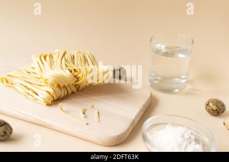 Natural homemade noodles with ingredients on a brown background. Horizontal orientation. Copy space. Stock Photo