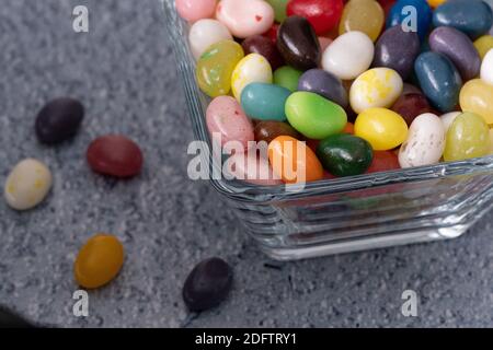 Jelly beans on blue background table, festive and colorful composition with candie, angle view shot Stock Photo