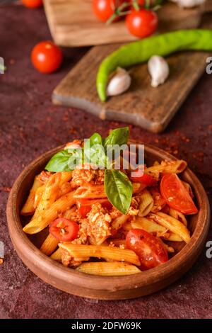 Bowl of penne pasta with tomato sauce on color background Stock Photo