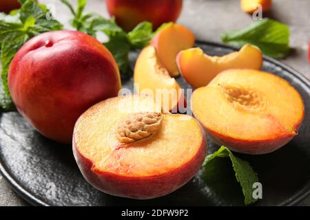 Plate with sweet ripe peaches on table Stock Photo