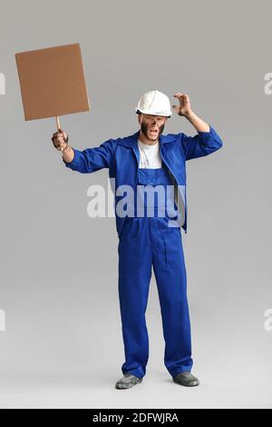 Protesting miner man with placard on grey background Stock Photo