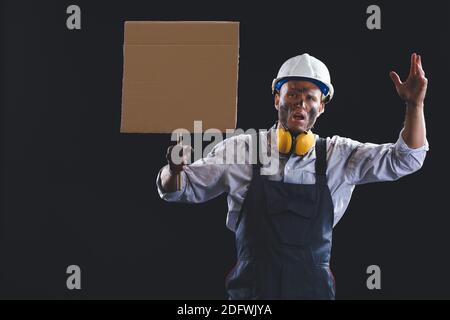 Protesting miner man with placard on dark background Stock Photo
