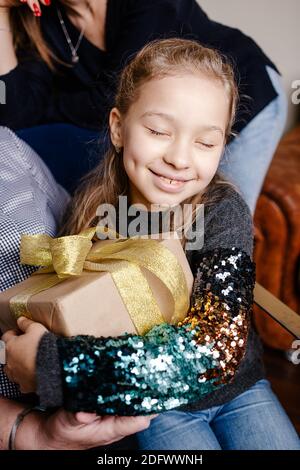 Small cute happy girl hugging her christmas present. Child excited about unpacking her gift. Merry Christmas and Happy Holidays! Stock Photo