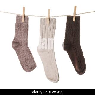 Warm socks hanging on clothes line against white background Stock Photo