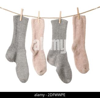 Warm socks hanging on clothes line against white background Stock Photo