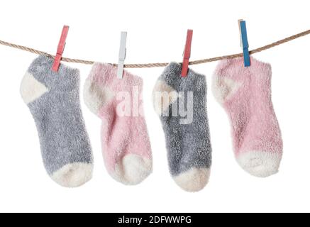 Warm socks hanging on clothes line against white background Stock Photo