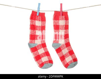 Warm socks hanging on clothes line against white background Stock Photo