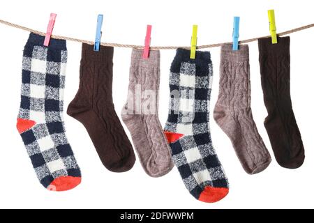 Warm socks hanging on clothes line against white background Stock Photo