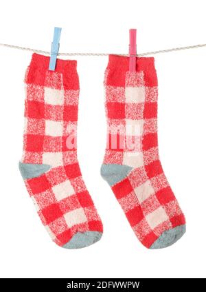 Warm socks hanging on clothes line against white background Stock Photo