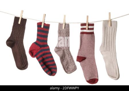 Warm socks hanging on clothes line against white background Stock Photo