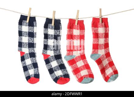 Warm socks hanging on clothes line against white background Stock Photo