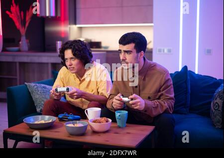 Happy male gamers playing video games at home. Stock Photo