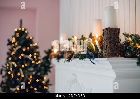 Christmas Fireplace, Xmas Lights Decoration, Tree Branches, candles and pine pieces Stock Photo