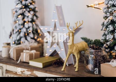 winter still life with Christmas decorations toy deer, star and gift boxes on light background. soft focus, blurred background Stock Photo