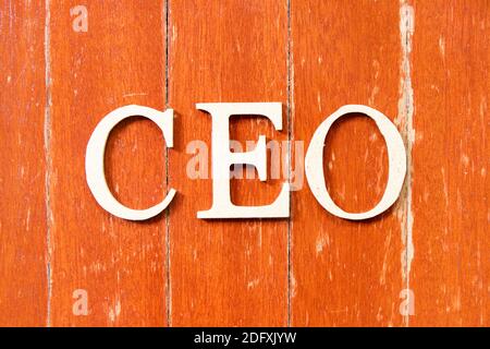 Alphabet letter in word CEO (Abbreviation of Chief Executive Officer) on old red color wood plate background Stock Photo