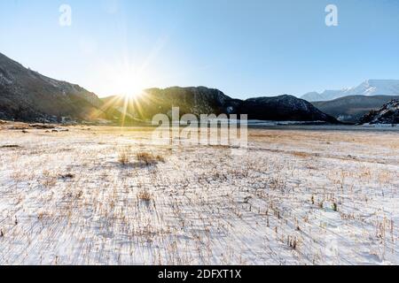 Early morning sunrise in steppes. Snow-covered pasture in the Altai Republic. The onset of winter, snow cover. Severe frost. Stock Photo