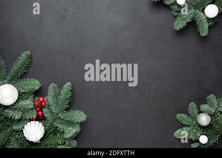 Christmas frame with fir tree on black concrete background. Top view copy space Stock Photo