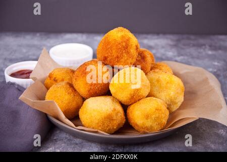 Potato croquettes balls on the plate and dips sauces. Stock Photo