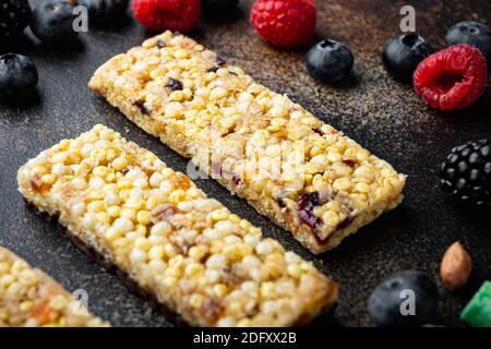 Homemade granola bars with mixed nuts, seeds and berries, on old dark table Stock Photo