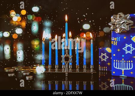 Jewish holiday. Hanukkah on menorah with burning candles for sparkle background with defocused colorful lights. Stock Photo