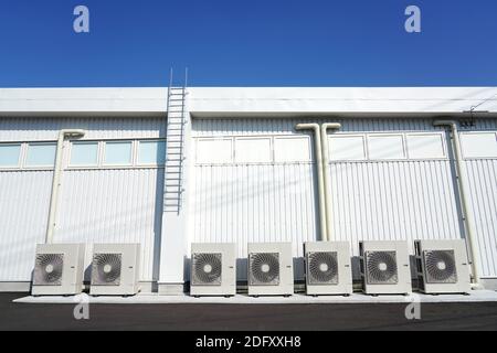 Row of the industrial air conditioning compressor outdoor unit installation of the building side wall Stock Photo