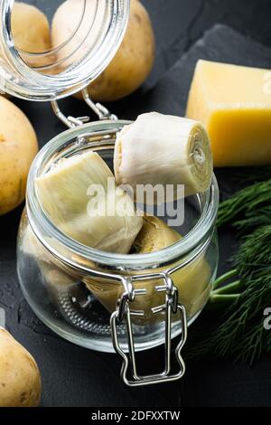 Pickled artichokes with oil, on black textured background Stock Photo
