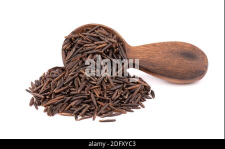 Wild black rice in wooden spoon, isolated on white background. Stock Photo