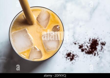 Cold summer drinks concept. Ice latte coffee in glass glass, top view, white background. Stock Photo