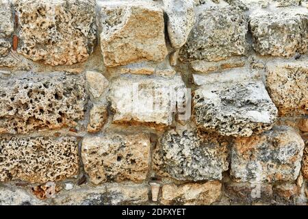 Background of the stone wall of the castle made of stones of different shapes and sizes and textures Stock Photo
