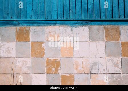 aged cream tiles. top made of blue wooden planks Stock Photo