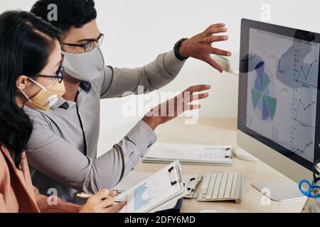 Coworkers discussing charts and diagrams Stock Photo