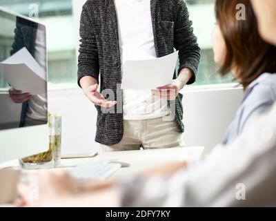 team of three asian business people working in office having a discussion Stock Photo