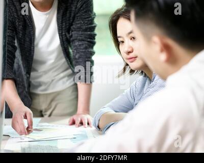 young asian business woman contemplating during meeting in office with two colleagues Stock Photo