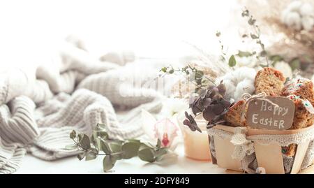 Easter still life with pieces of festive cupcake, eggs and flowers on a blurred light background. Easter holiday concept. Stock Photo