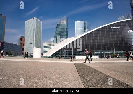 People walking across open area at La Defense business district in Paris. The modern skyscrapers on the background Stock Photo