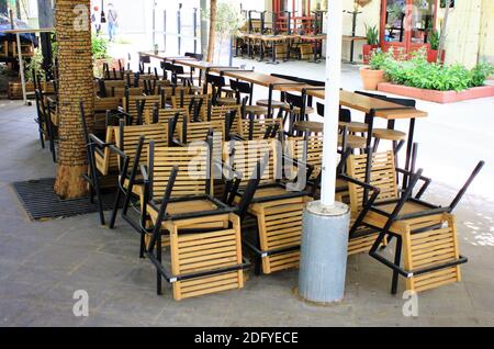 Tables and chairs stacked outside closed cafe-restaurant due the Coronavirus lockdown - Athens, Greece, May 6 2020. Stock Photo