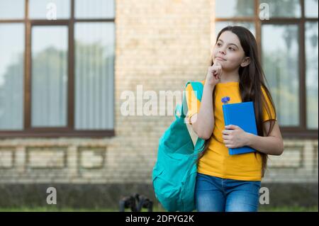 Imagination is more important than knowledge. Serious child hold book with thoughtful look. School education. Fantasy and imaginative thinking. The best use of imagination is creativity, copy space. Stock Photo