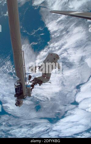 ISS - 08 July 2006 - Anchored to the Space Shuttle Discovery's Remote Manipulator System/Orbiter Boom Sensor System (RMS/OBSS) foot restraint, astrona Stock Photo