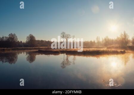 Sunny frosty dawn on a foggy swamp. Soft focus. Stock Photo