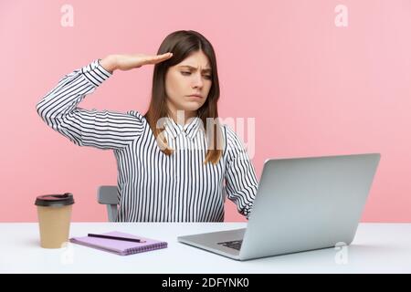 Responsible woman office worker saluting, listening to order and looking at laptop screen on video call, online conference from home office. Indoor st Stock Photo