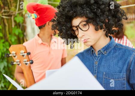 Child with a funny wig in Mardi Gras before the talent show performance at the holiday camp Stock Photo