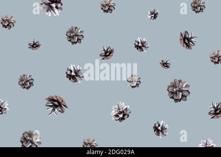 Hello winter concept. Winter pattern with flying silver pine cones on blue background. Zero gravity concept. Copy space. Stock Photo