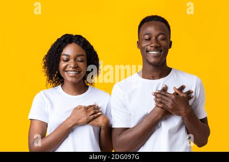 Closeup of black couple praying with closed eyes Stock Photo