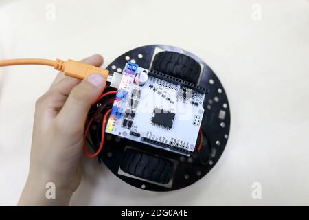 Child holding robot at table in workshop Stock Photo