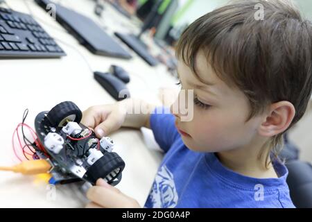 Child programming robot at table in workshop Stock Photo