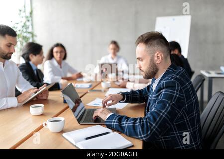 Businessman Using Laptop Working During Corporate Meeting In Modern Office Stock Photo