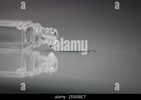 small transparent glass jar dripping with white background and reflection Stock Photo